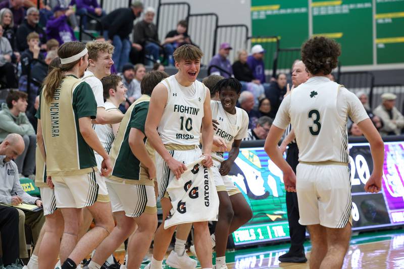 Bishop McNamara's Coen Demack turns to celebrate a scoring play with teammates during the Fightin' Irish's 61-24 victory over Wilmington in the IHSA Class 2A Seneca Sectional semifinal on Tuesday, March 3, 2026.