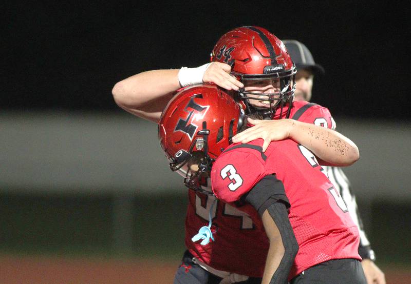 Huntley’s  Haiden Janke, back, and Omare Segarra celebrate a second-half touchdown against Niles West in first-round Class 8A playoff football action at Huntley Friday.