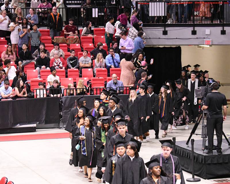 DeKalb High School seniors file in to the NIU Convocation Center in DeKalb on Saturday, May 24, 2025, for the Class of 2025 Commencement ceremony.