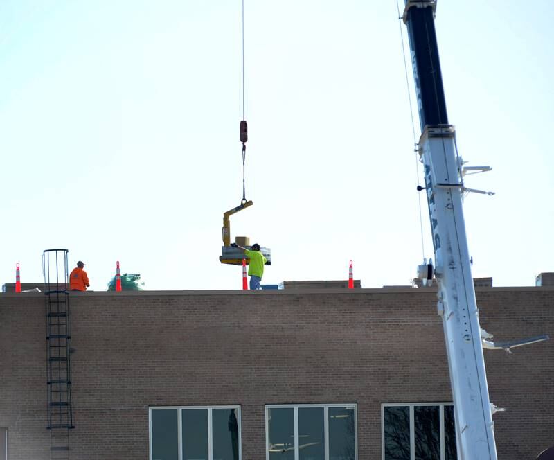 Workers unload solar panel materials on the roof of Polo Community High School on Saturday, March 2, 2024.
