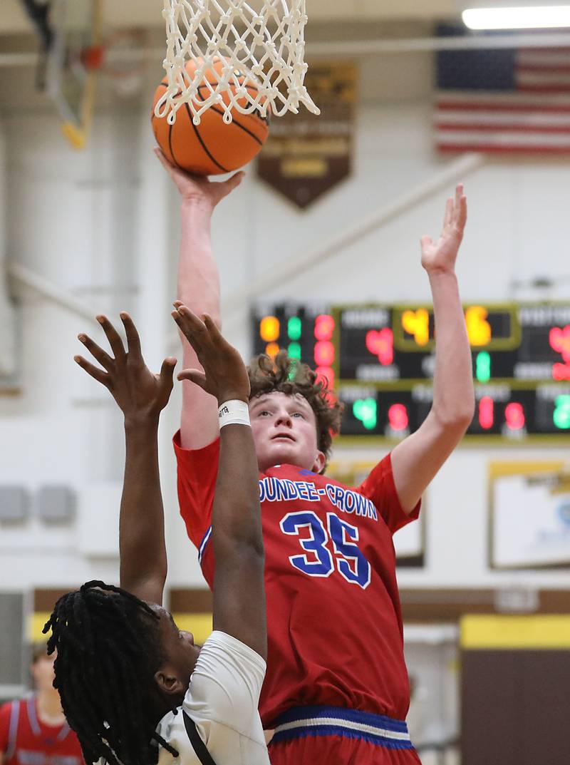 Dundee-Crown's Hudson Reardon shoots the ball over Jacobs' Malachi Bell during a Fox Valley Conference boys basketball game on Tuesday, February. 3, 2026, at Jacobs High School in Algonquin.