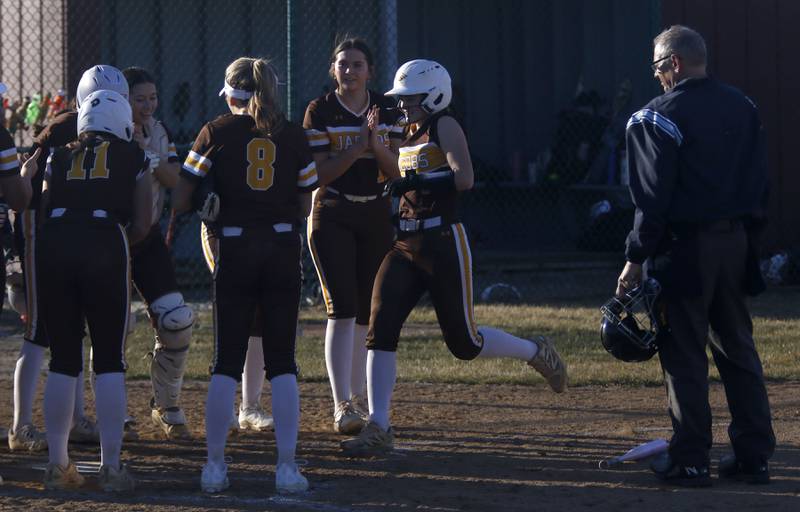 Jacobs' Emily Popilek  is greeted by here teammates after hitting a home run during a nonconference softball game against Marengo on Monday, March 9, 2026, at Marengo High School.