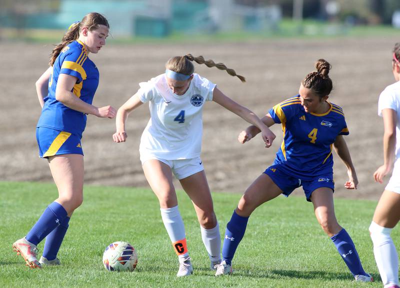 Woodstock’s Lily Novelle, center, navigates through Johnsburg’s Elaina Moss, left, and Ava Jablonski in varsity soccer on Wednesday, April 23, 2025, at Johnsburg High School in Johnsburg.