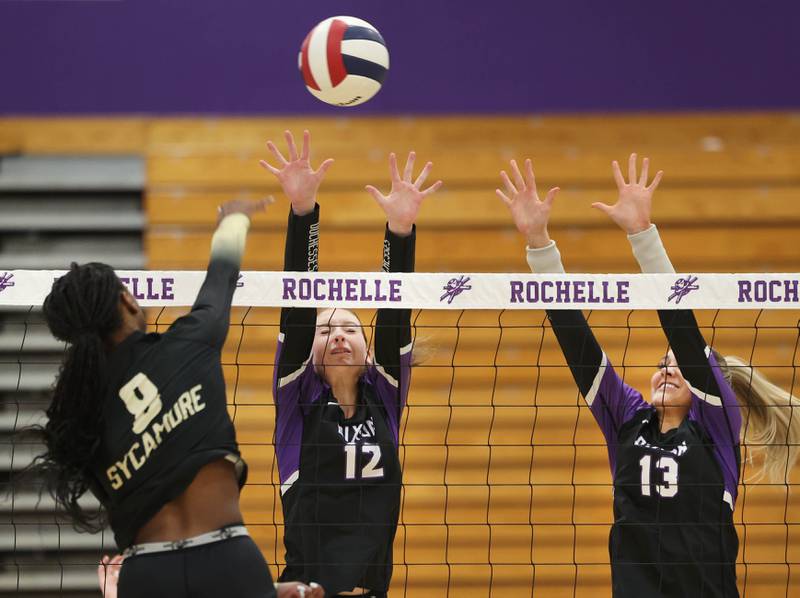 Dixon’s Izzy Queckboerner (left) and Solis Thompson try to block the spike of Sycamore's Khiara Thomas Thursday, Oct. 30, 2025, during their Class 3A regional championship match in Rochelle