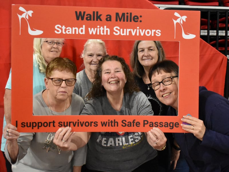 Participants pose for a photo at Safe Passage's annual Walk A Mile in Their Shoes event on April 18, 2026, at the Northern Illinois University Convocation Center in DeKalb. The event, held to raise awareness of sexual violence and supoprt survivors, was hosted by the nonprofit as part of Sexual Assault Awareness Month.