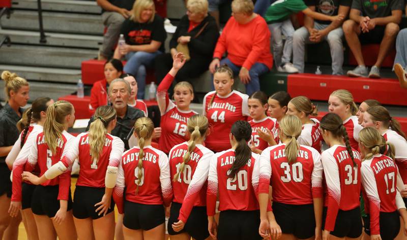 Members of the L-P Cavalier volleyball team huddle with head coach Mark Haberkorn while playing Princeton on Tuesday, Aug. 26, 2025 in AJ Sellett Gymnasium at L-P High School.