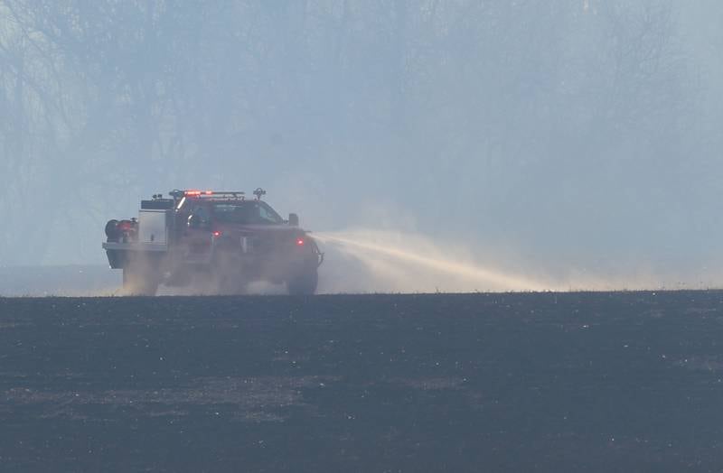 A brush truck sprays water on a charred farm field near the 26000 block of 2500 East Street on Wednesday, Feb. 18, 2026 near Ohio. A Mutual Aid Box Alarm call was elevated to the second-alarm for the brush fire. Bureau County Fire departments from Princeton, Ohio, Malden and others assisted with the fire.