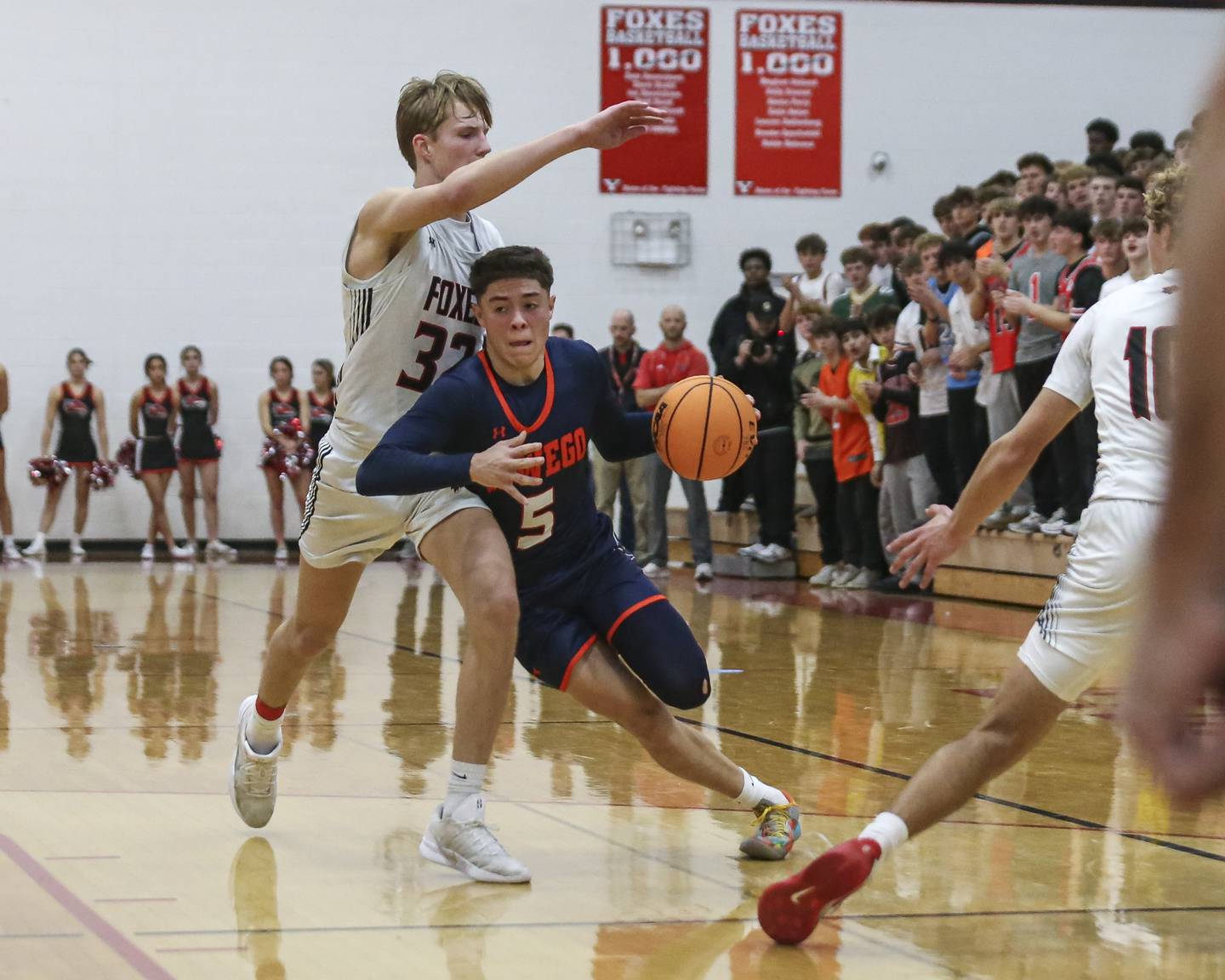 Oswego's Mariano Velasco (5) drives past the defense of Yorkville's Joey Jakstys (32) during their basketball game between Oswego at Yorkville Friday, Dec 12, 2025 in Yorkville.