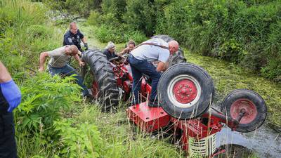 Firefighters rescue man pinned under a tractor in water near Harvard 