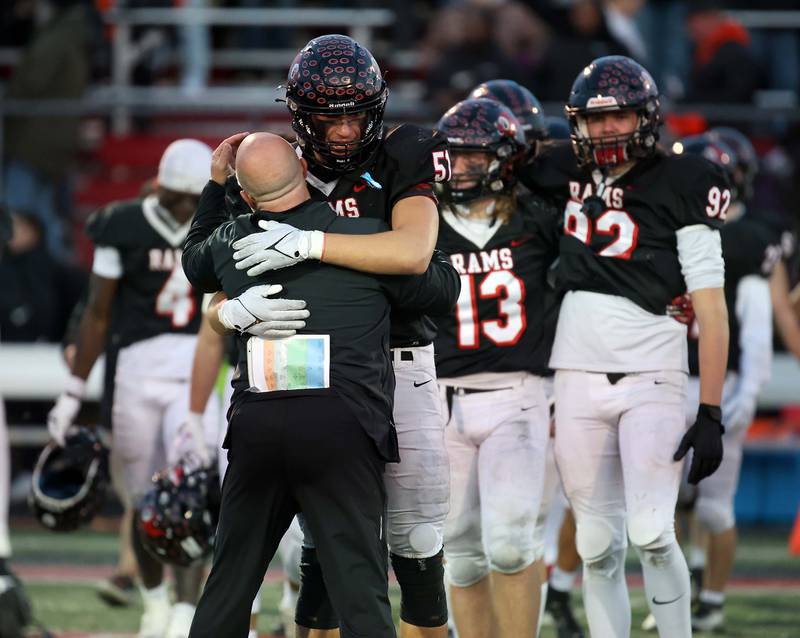 Glenbard East's Daniel Zlatanov (51) gets a hug from one of his coaches after their loss to Normal during the IHSA Class 7A quarterfinals Saturday November 11, 2023 in Lombard.