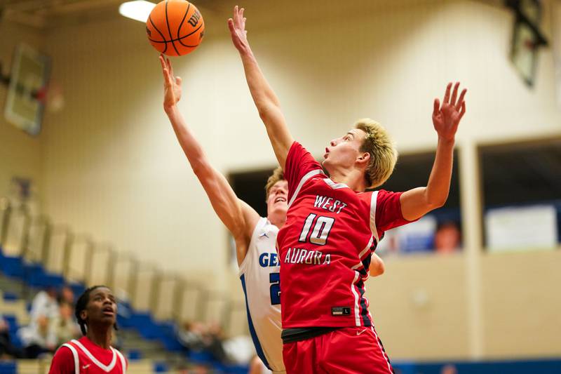 West Aurora's Kael Adkins (10) defends the paint against a shot in the post from Geneva’s Hudson Kirby (25) during a MLK Day of Hoops basketball game at Geneva High School on Monday, Jan. 20, 2025.
