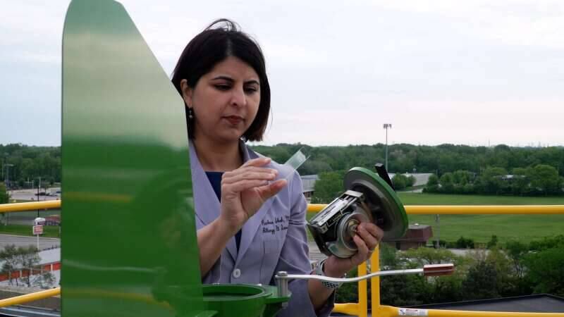 Dr. Rachna Shah of the Loyola Medicine Allergy Count collects a microscope slide full of pollen from a counter on the roof of Gottlieb Memorial Hospital in Melrose Park.