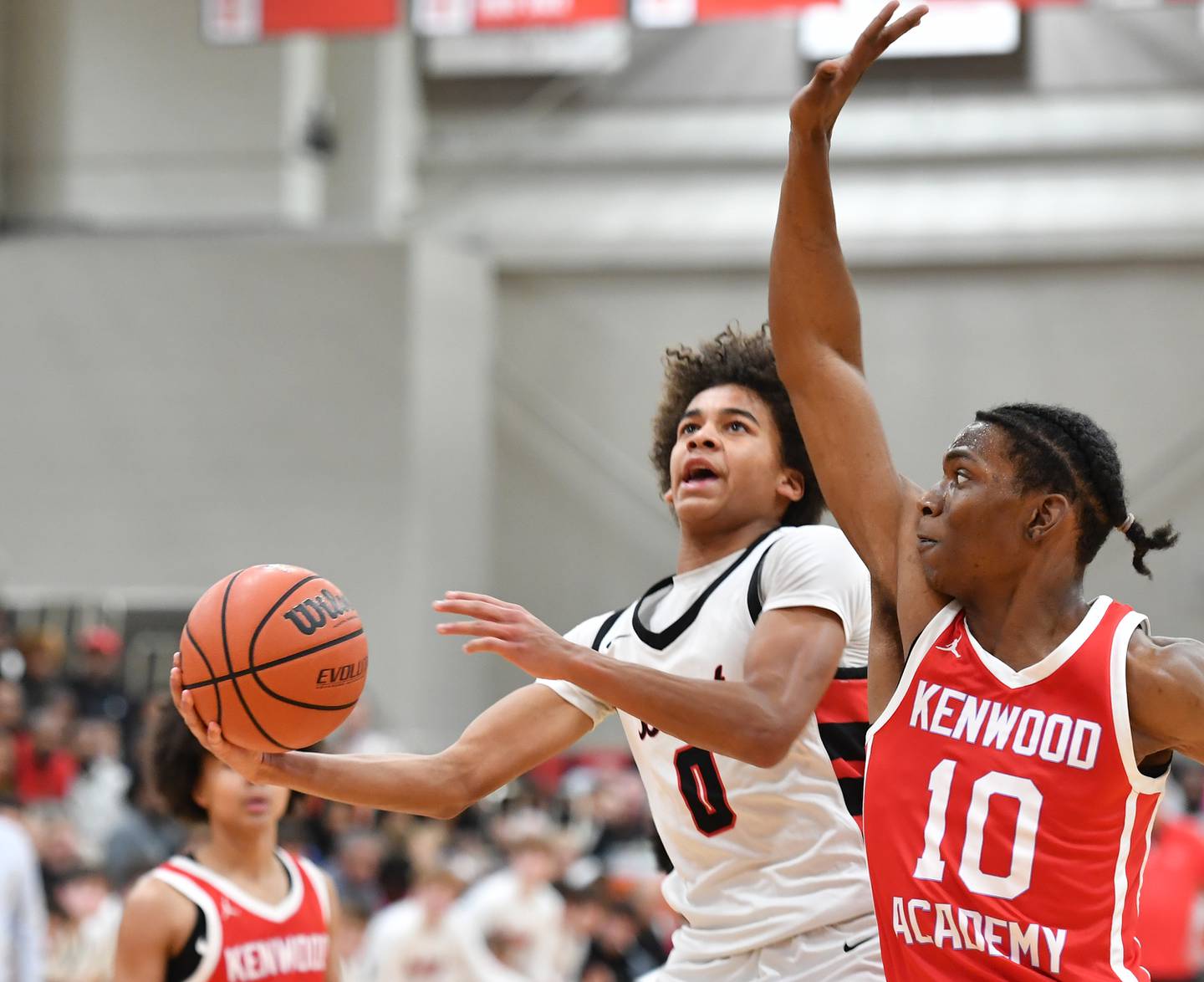 Benets Brayden Fagbemi (0) lays the ball up as Kenwood's Chris Riddle (10) defends during a "When Sides Collide" invitational game on Jan. 21, 2023 at Benet Academy in Lisle.