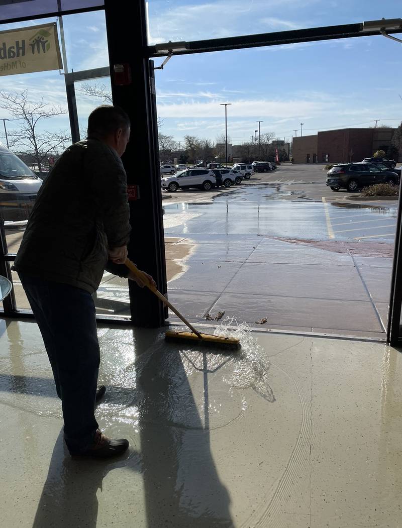 A worker pushes out water from Habitat for Humanity's ReStore on Monday, Nov. 14, 2022, in Woodstock. The store is closed until further notice due to flooding from a main break.
