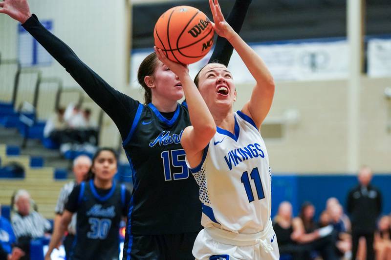 Geneva’s Heidi Clesen (11) shoots the ball in the post against St. Charles North's Bronwyn How (15) during a game at Geneva High School on Thursday, Dec. 4, 2025.