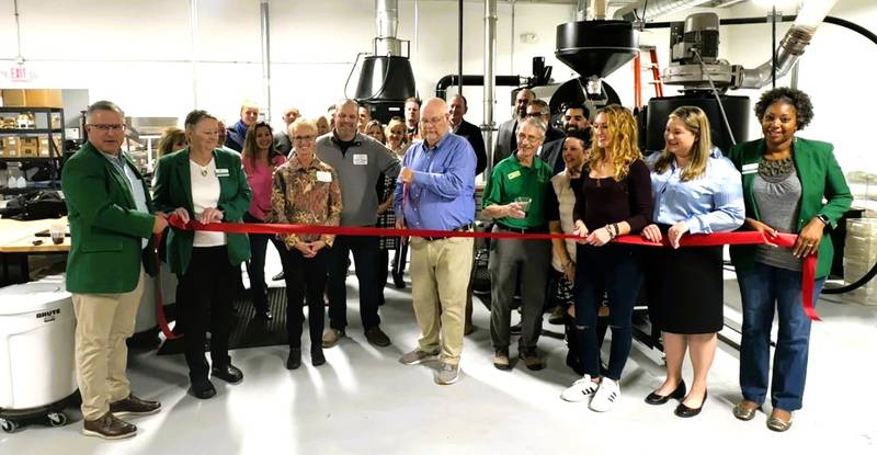 Jack Shipley, founder of Conscious Cup Coffee Roasters, cuts the ribbon celebrating Conscious Cup Coffee Roasters' new 5,700 square foot headquarters in Crystal Lake.  He is joined by his wife and founding partner, Roseanna Shipley, and their son and managing partner, Michael Shipley, along with their staff and the staff and members of the Cary-Grove Area Chamber of Commerce, the Crystal Lake Chamber of Commerce, and the Barrington Area Chamber of Commerce.