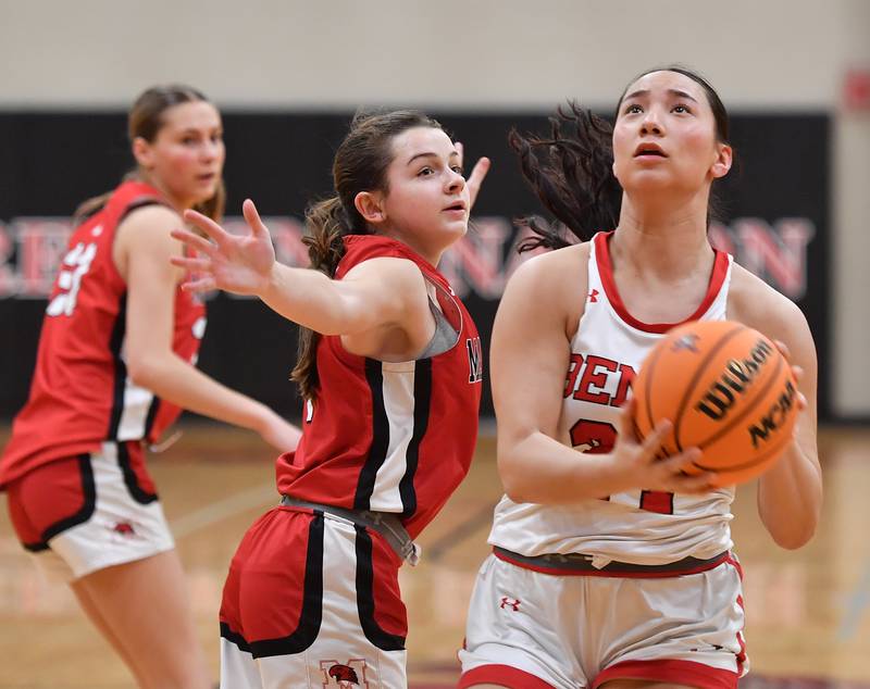 Benet’s Emma Briggs (right) goes to the basket past Marist’s Olivia Cosme during a game on January 8, 2025 at Benet Academy in Lisle.