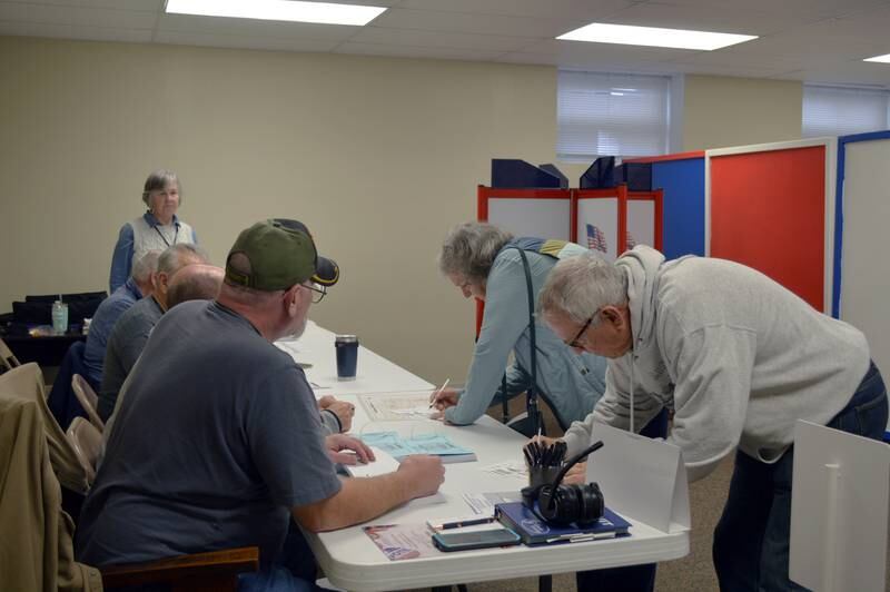 Rob Urish (right) and Karen Urish sign voting cards to receive their ballots for the election Tuesday, Nov. 5, 2024, in the Mt. Morris Village Hall basement.