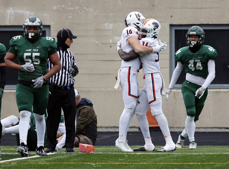 Oswego's Ammar Banire (34) celebrates a touchdown with Ryan Wynn (16) during the varsity football second-round 8A playoff game between Oswego and Lane Tech on Saturday, Nov. 8, 2025 in Chicago.