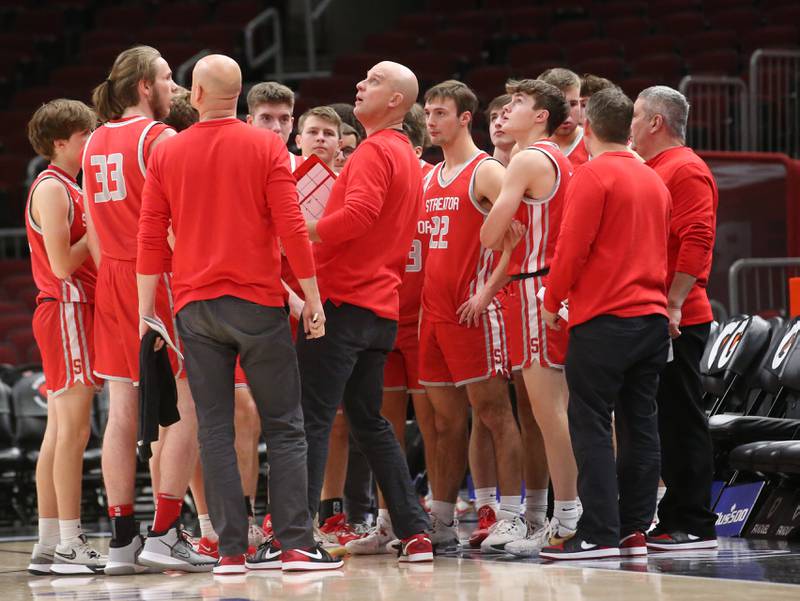 Streator head boys basketball coach Beau Doty (center) glances up at the scoreboard while huddling the team during a timeout  against Seneca during a game on Tuesday, Dec. 21, 2023 at the United Center in Chicago.
