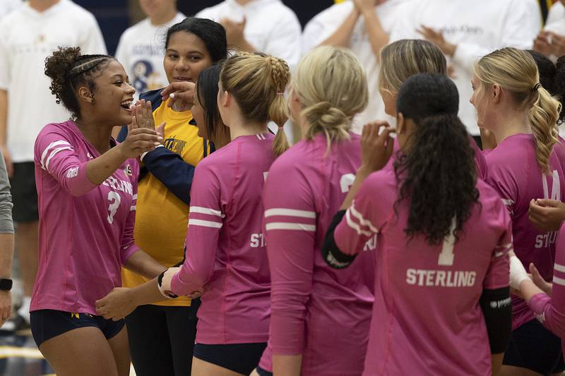 Sterling’s Delali Amankwa (left) celebrates with teammates Thursday, Oct. 24, 2024 after being presented a game ball for breaking the school assists record in volleyball.