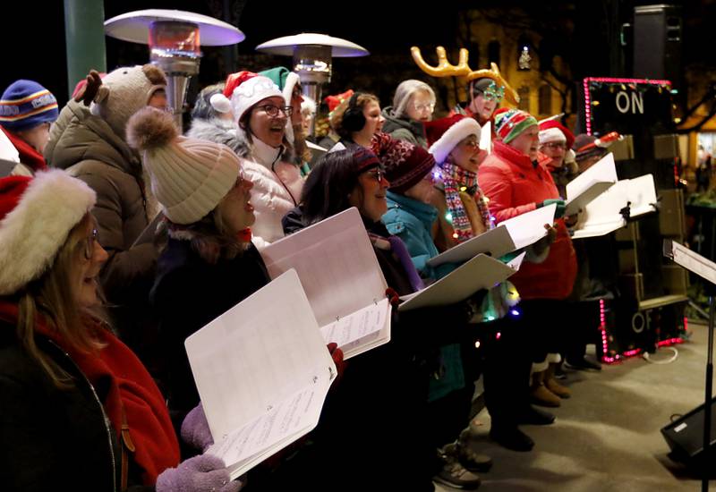 Members of the Woodstock Community Choir sing Christmas carols during the Lighting of the Square Friday, Nov. 29, 2024, in Woodstock. The annual holiday season event featured brass music, caroling, free doughnuts and cider, food trucks, festive selfie stations and shopping.