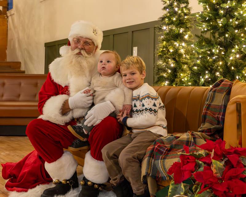 Santa holds Campbell Kasik whilst brother Harris embraces them when posing for photo on Sunday, December 14, 2025 at The Coffee Barn in Mendota.