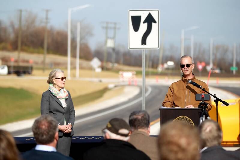 Kane County Department of Transportation Director Carl Schoedel addresses a small crowd gathered in the middle of Bliss Road with Kane County Board Chairman Corinne Pierog before the ribbon cutting for the $12 million realignment of Bliss Road and a new roundabout connecting Bliss Road, Main Street Road and Fabyan Parkway in Blackberry Township on Thursday, Nov. 16, 2023.