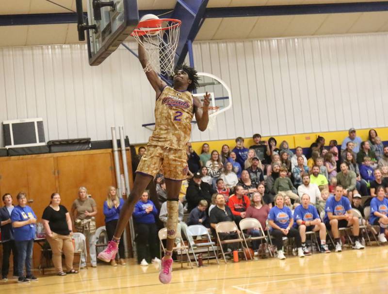 Harlem Wizards player Devale Johnson, (Too Tall) dunks the ball during the Harlem Wizards event on Tuesday, Oct. 28, 2025 in Pannebaker Gymnasium at Logan Jr. High School in Princeton.
