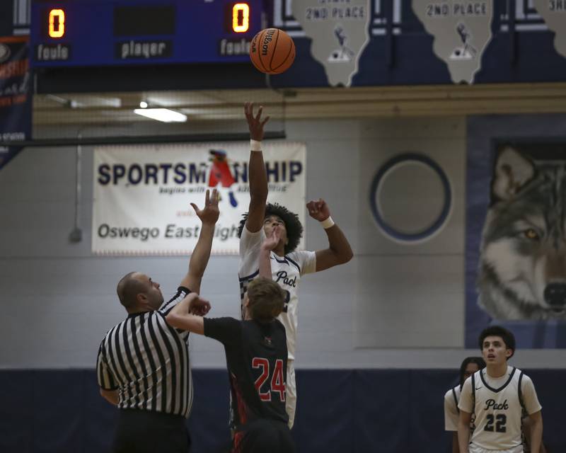 Oswego East's Jacsen Tucker (2) tips off against Yorkville's Nathan Kubin (24) during their basketball game between Yorkville at Oswego East. Friday, Dec 19, 2025 in Oswego.