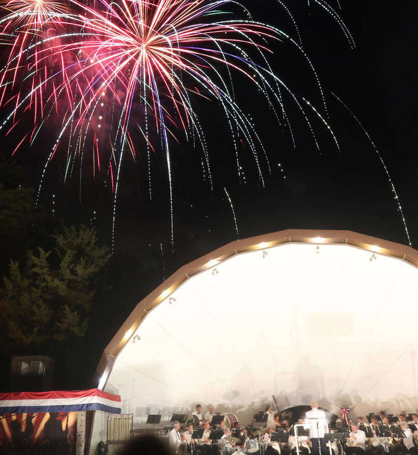 The DeKalb Municipal Band accompanies the firework display at Hopkins Park in DeKalb during the 2015 Fourth of July celebration.