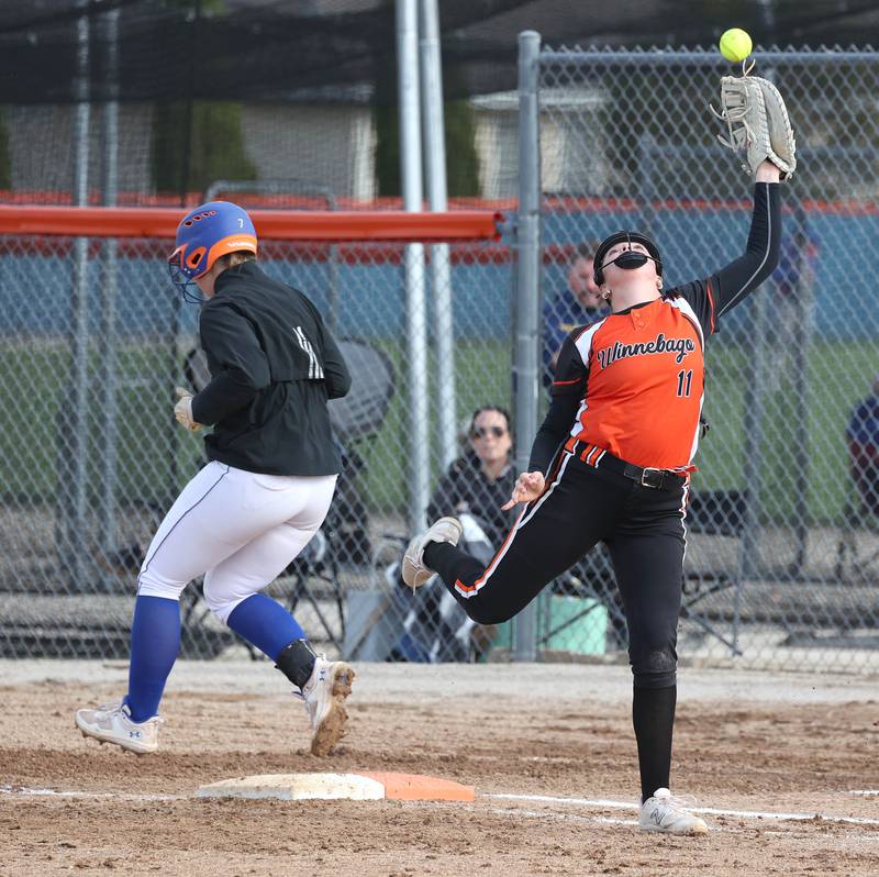 Genoa-Kingston’s Elizabeth Davis is safe at first as the high throw gets by Winnebago’s Joleigh Williams during their game Monday, April 21, 2025, at Genoa-Kingston High School.
