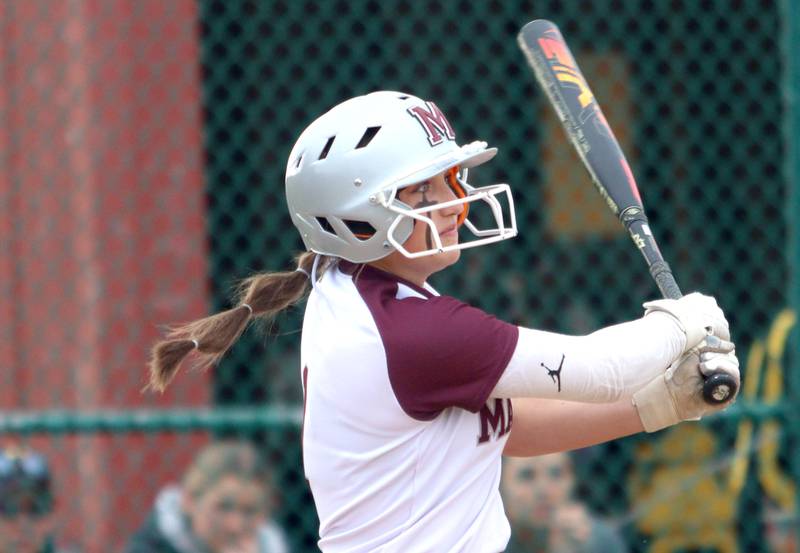 Marengo’s Gabby Christopher watches the flight of a home run against Harvard in varsity softball at Marengo Thursday.
