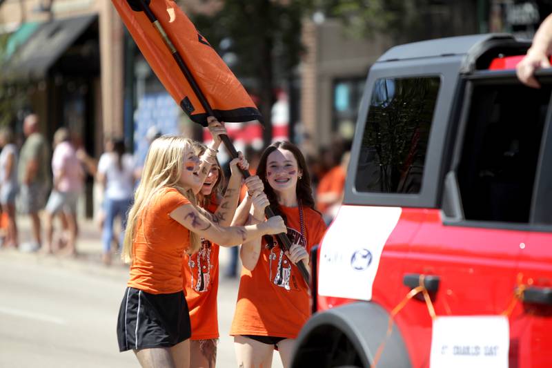 (Left to right) Bella Kaschke, Riley Pakosta and Averie Foulkes carry the Class of 2027 flag during the school’s homecoming parade on Main Street through Downtown St. Charles on Thursday, Aug. 31, 2023.