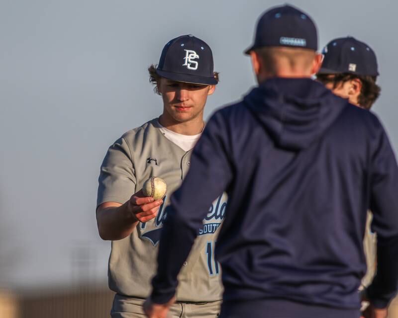 Plainfield South's Cody Hogan (11) offers the ball to head coach Keith Halverson after being relieved during baseball game between Plainfield South at Oswego on Monday, April 14, 2025 in Oswego.