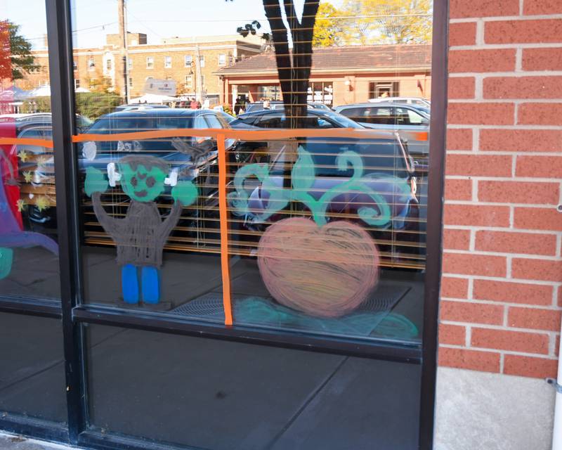 A pumpkin and Frankenstein were one of many things painted on windows downtown Downers Grove during the during the Halloween Window painting event on Saturday Oct. 21, 2023.