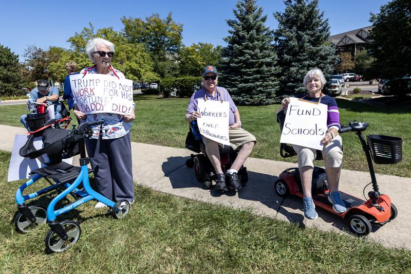 Audrey Kelly, Bob Blackburn, and Kathy Hultsch hold-up signs during the ‘Workers Over Billionaires’ Labor Day Protest on the 1100 block of N. River Rd. in Shorewood, IL, on Sept. 1, 2025.