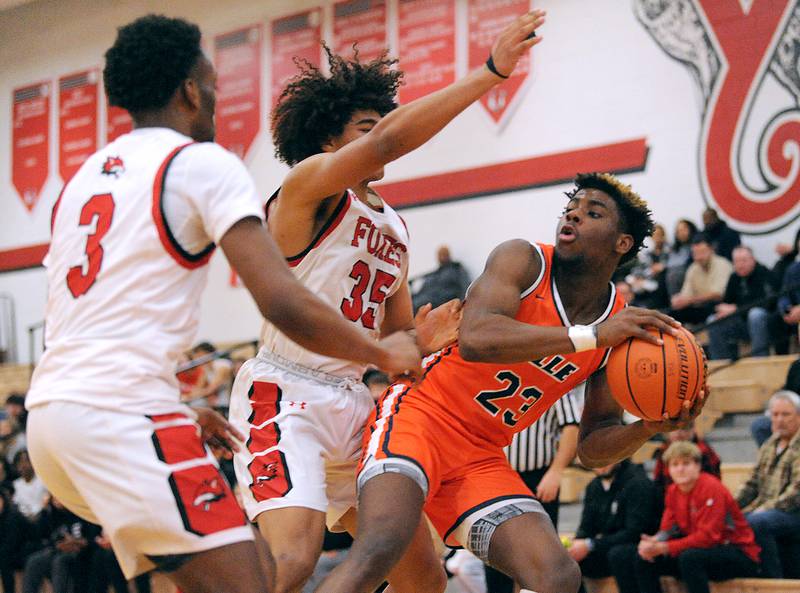 Romeoville's Denonte Cunningham (23) looks for a teammate against Yorkville defender LeBaron Lee (35) during a boys' basketball game at Yorkville High School on Tuesday, Jan. 10, 2023.