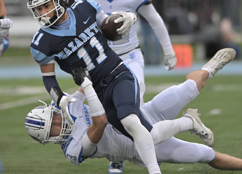 St. Francis’ Seth Valeri pulls down Nazareth’s James Penley in the IHSA Class 5A state semifinal football game in La Grange on Saturday, Nov. 23, 2024.
