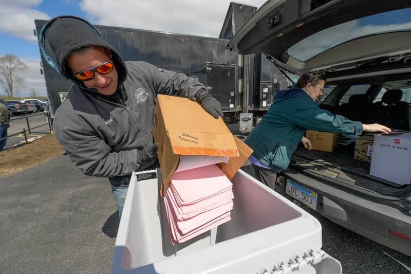 Mike Lambert from Secure Document Solutions collects unwanted paper documents for shredding from Susan Cechner of st. Charles during the Geneva Earth Day Celebration at Peck Farm in Geneva on Saturday, April 20, 2024.