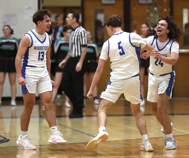Woodstock's Ryan Murray (left) and JJ Stokes (right) celebrate Max Beard\s three pointer to end the first half during a Kishwaukee River Conference boys basketball game on Wednesday, February. 18, 2026, at Woodstock High School.