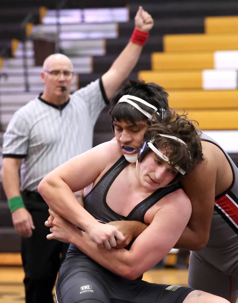 Ottawa’s Hector Valdez wraps up Sycamore’s Cayden Larson during their 215 pound match Thursday, Dec. 14, 2023, at Sycamore High School.