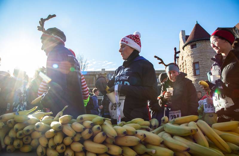 Runners grab snacks and water after the 13th annual Lions Charities Reindeer Run 5K Wheaton on Saturday, Dec. 7, 2024.