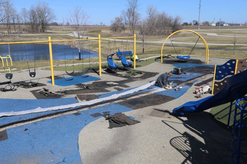 Workers with Team Reil Inc. removes pieces of the surface of the playground at Rotary Park on Monday, March 11, 2024 in La Salle. The playground will be re-surfaced and completed on March 25. The playground will be closed until work is finished.