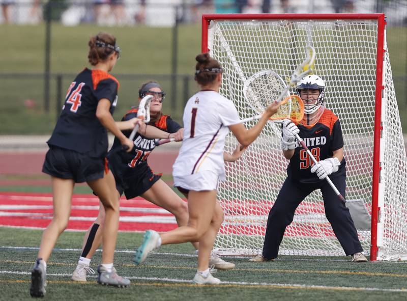 Crystal Lake Central Coop's Anya Korczak (98) tends goal as Loyola Academy's Emily Couri (1) closes in during the lacrosse state semi-final match between Crystal Lake Central and Loyola Academy on Thursday, June 5, 2025 in Hinsdale.