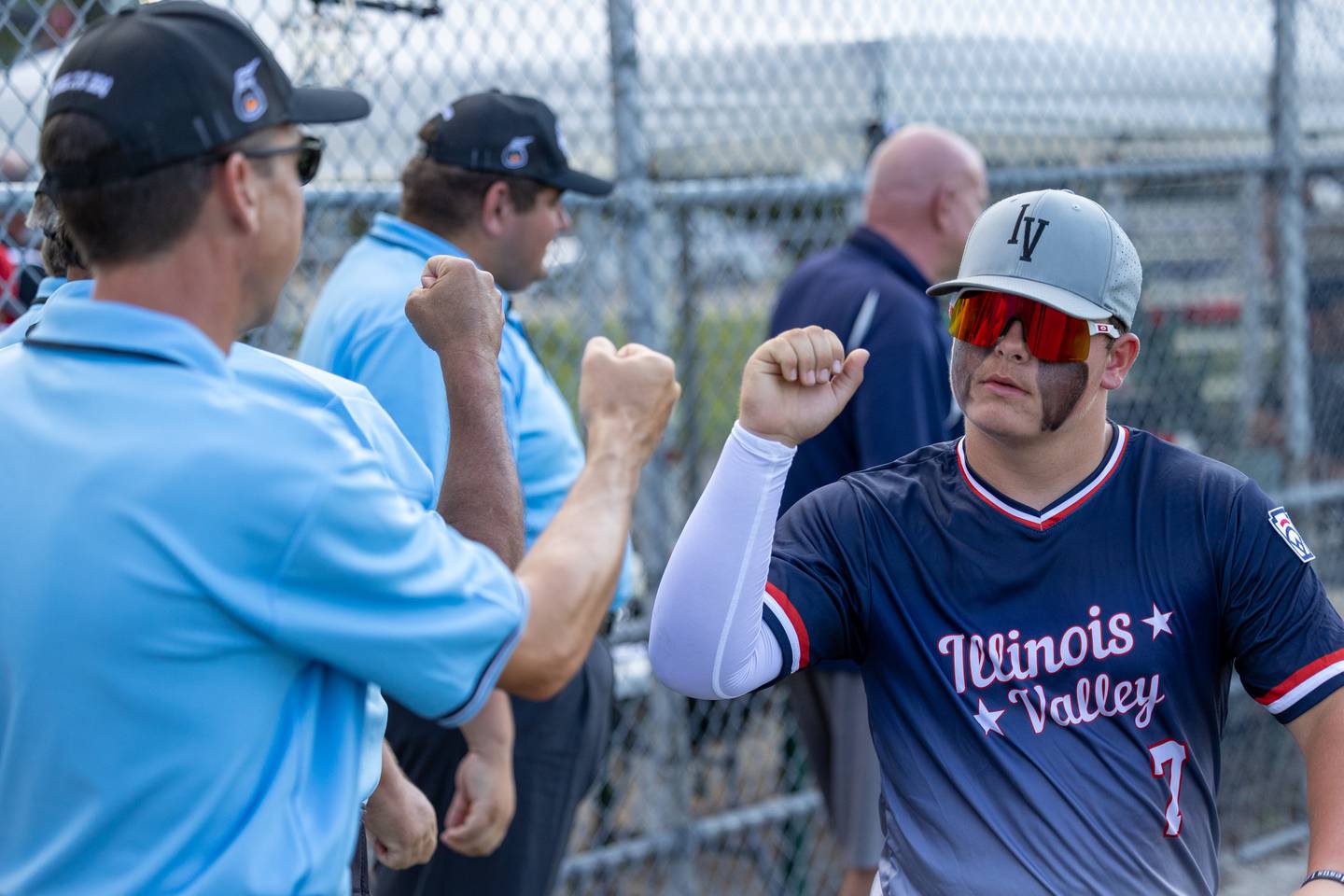 Espen McFadden of Illinois District 20 fist bumps umpire Chris Ekstrom on Saturday, July 12, 2025 at Washington Park in Peru.