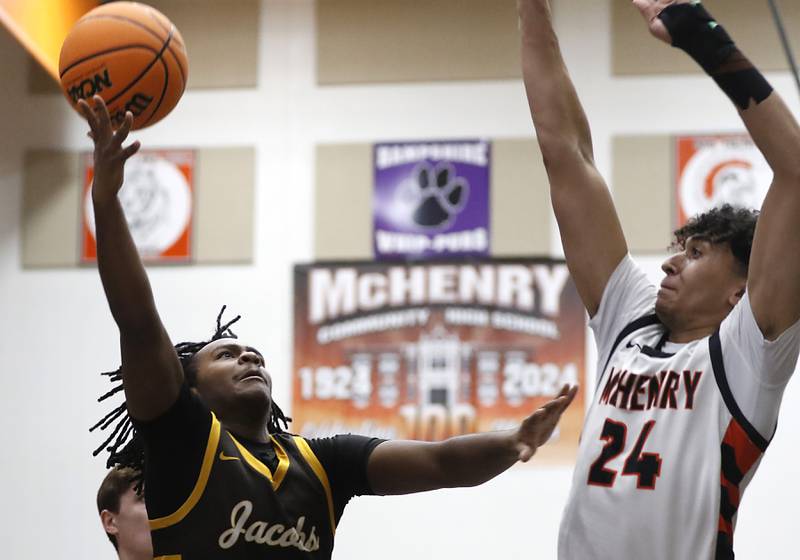 Jacobs' Emaan Thomas drives to the basket against McHenry's Adam Anwar during an IHSA Class 4A McHenry Regional basketball game on Wednesday, Feb. 26, 2025, at McHenry High School.