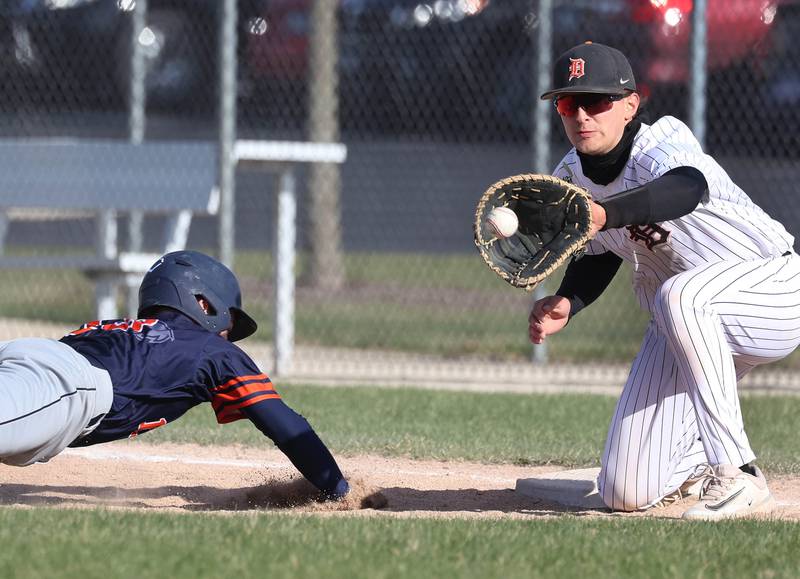 DeKalb's Paul Kakoliris takes the throw on a pickoff attempt as Naperville North’s Lawton Close dives back in safely Tuesday, April 15, 2025, during their game at DeKalb High School.