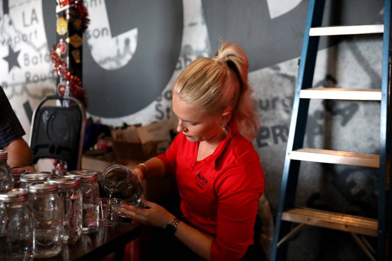 Cassandra Armin, a civil engineer for the City of Aurora, pours water samples to be taste-tested during the annual Kane County Water Association's annual water-tasting contest at Global Brew in St. Charles on Thursday, Dec. 21, 2023.