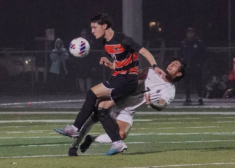 St. Charles East's Michael Grezenko (12) challenges West Chicago's Rafael Posada (7) for the ball during a class 3A sectional semifinal soccer match at West Chicago High School on Wednesday, Oct. 25, 2023.